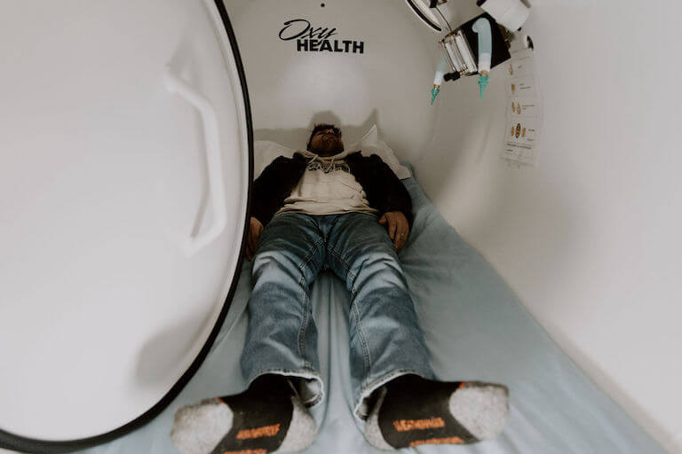 Patient laying in hyperbaric oxygen chamber therapy