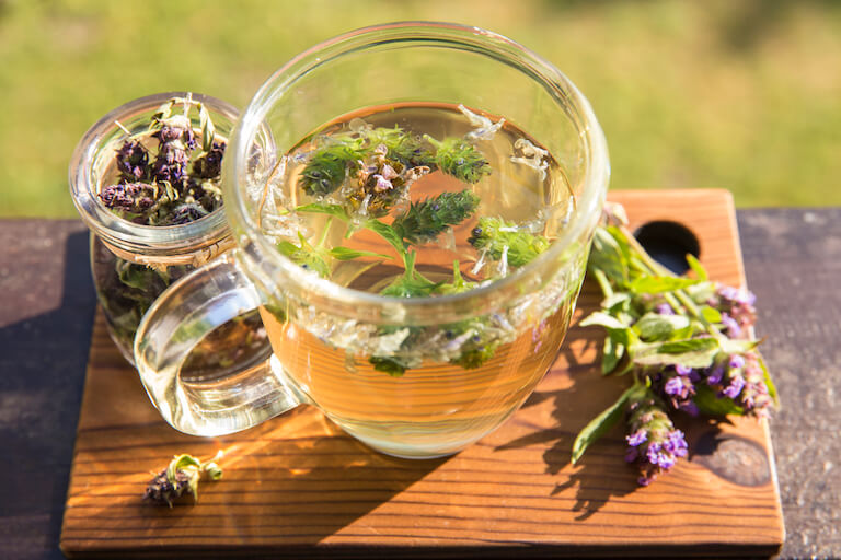 A fresh herbal tea sitting on a cutting board.